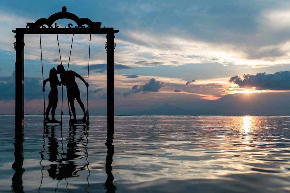 Swinging over ocean at couples resort.